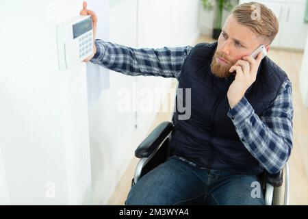 Behinderter im Rollstuhl am Telefon Stockfoto