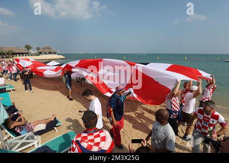 Am Hilton Doha Beach in Doha, Katar, am 17. Dezember 2022, werden die Unterstützer Kroatiens vor der FIFA-Weltmeisterschaft Katar 2022 im Bronzemedaillenspiel zwischen Kroatien und Marokko gesehen. Die Fans tragen eine 200 Meter lange Flagge von Kroatien. Foto: Goran Stanzl/PIXSELL Stockfoto