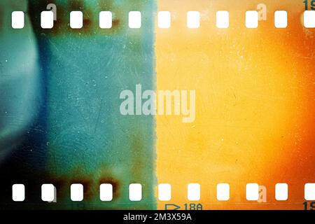 Staubige und schmutzige 35-mm-Filmtextur oder -Oberfläche. Perforierter, zerkratzter Kamerafilm isoliert auf weißem Hintergrund. Stockfoto