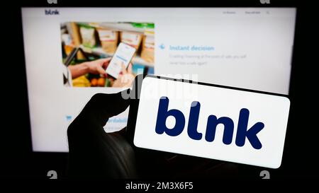 Person, die ein Mobiltelefon mit dem Logo des ägyptischen Unternehmens Blnk Consumer Finance SAE auf dem Bildschirm vor der Unternehmenswebseite hält. Konzentrieren Sie sich auf das Display des Telefons. Stockfoto