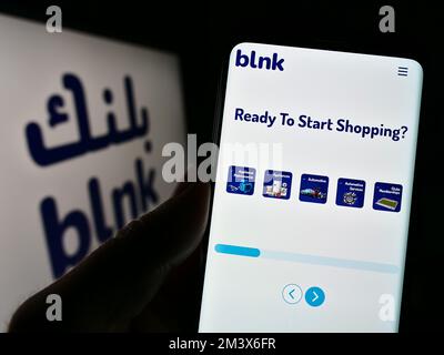 Person, die ein Mobiltelefon mit einer Webseite des ägyptischen Unternehmens Blnk Consumer Finance SAE auf dem Bildschirm mit Logo hält. Konzentrieren Sie sich auf die Mitte des Telefondisplays. Stockfoto