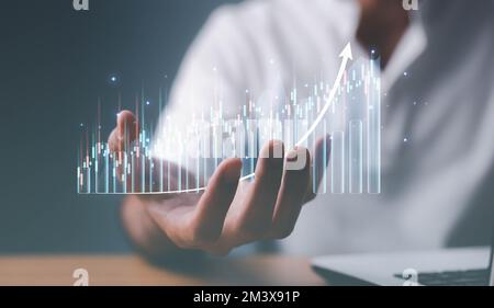 Ein männlicher Investor-Analyst, der ein Smartphone in der Hand hält und Börsenhandelstabellen analysiert, indiziert den Preis der Datenprüfung mithilfe von mobilen Börsen Stockfoto
