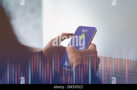 Analysten männlicher Händler, die ein Smartphone in der Hand halten und Börsenhandelstabellen analysieren Indizes für die Datenprüfung des Kurses mittels mobiler Börsenextrakte Stockfoto