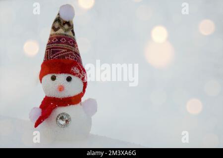 Schneehintergrund. Frohe Weihnachten und Neujahr Grußkarte mit Kopie. Ein glücklicher Schneemann steht in der Weihnachtslandschaft. Wintermärchen. Stockfoto