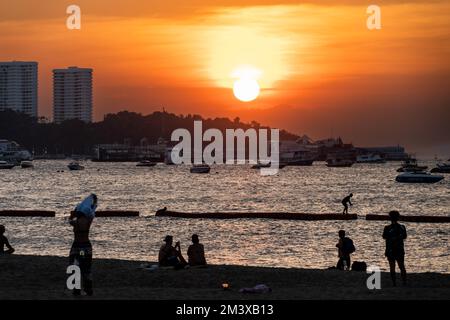 Pattaya, Chonburi, Thailand. 17.. Dezember 2022. Menschen hängen bei Sonnenuntergang am Pattaya Beach ab. Das tägliche Leben in Pattaya, Provinz Chonburi, Thailand am 17. Dezember 2022. Das bei Touristen sehr bekannte Gebiet ist einer der Schwerpunktbereiche, die die thailändische Tourismusbehörde (Tat) gefördert hat, um mehr ausländische Touristen in das Land zu locken und damit seine tourismusabhängige Wirtschaft zu retten. (Kreditbild: © Matt Hunt/ZUMA Press Wire) Stockfoto