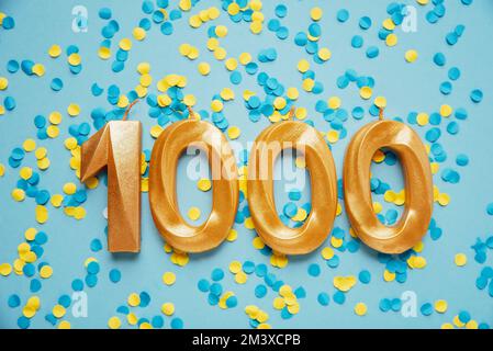 1000 eintausend Follower Abonnentenkarte Goldene Geburtstagskerze auf gelb-blauem Konfetti-Hintergrund. Vorlage für soziale Netzwerke, Blogs. Feier-Banner. 1000 Online-Community-Fans. Stockfoto