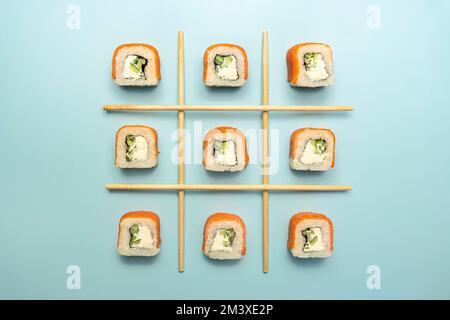 Sushi Brötchen Philadelphia mit Lachs und Avocado. Brötchen Sie zum Essen auf dem blauen Tisch. Asiatische oder japanische Küche, orientalische Küche. Schließen. Draufsicht Stockfoto