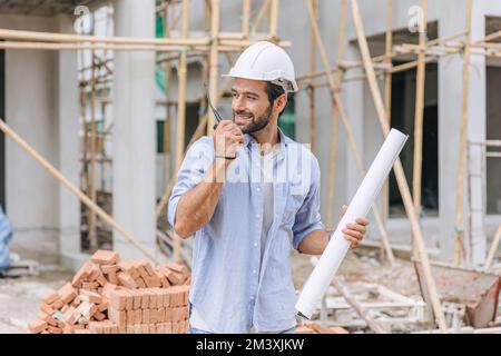 Erwachsenenberufsarbeit männlicher Baustellenarbeiter. Architekt Heimprojekt Chefingenieur mit Grundriss. Stockfoto