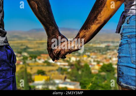 Ein Teenager-Paar, das Händchen hält auf einer Cascamorras-Party Stockfoto