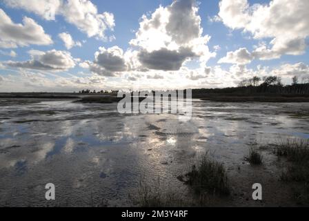 Reflexionen des blauen Himmels und der weißen Wolken in den Schlammräumen der Hazelwood Marshes, an der Alde- und Ore-Mündung, Suffolk, 27. August 2022 Stockfoto