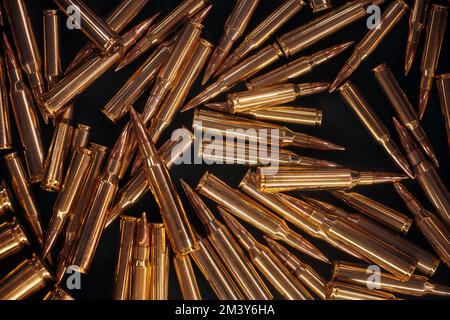 Ammonution auf dunklem Tisch. Munitionslager, Kriegsmassage. Munition und Militärtechnologie. Waffen und Ammo-Hintergrund. Herstellung von Munition bei der Stockfoto