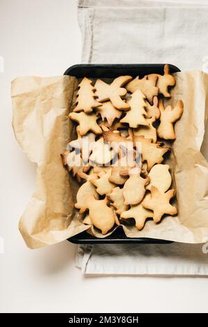 Ein Haufen weihnachtlicher Lebkuchen-Kekse auf dem Backblech. Stockfoto