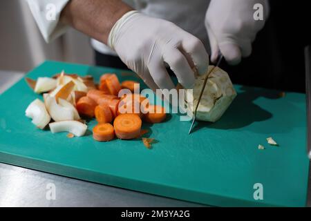 Zerkleinern Sie Sellerie von Hand auf einem Schneidebrett. Kochen Sie Gemüse zerkleinern Stockfoto