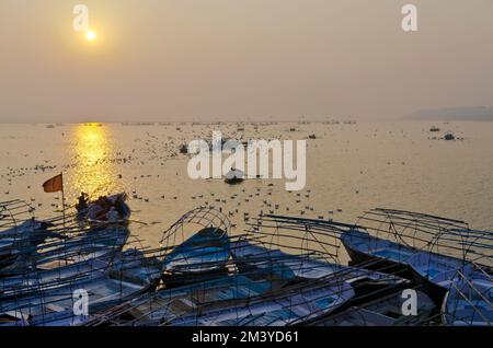 Sonnenaufgang über Booten mit Pilgern in Sangam, dem Zusammenfluss der heiligen Flüsse Ganges, Yamuna und Saraswati Stockfoto