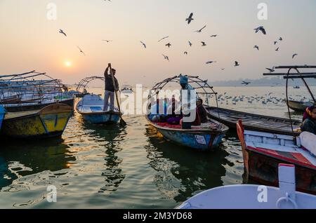 Sonnenaufgang über Booten mit Pilgern in Sangam, dem Zusammenfluss der heiligen Flüsse Ganges, Yamuna und Saraswati Stockfoto