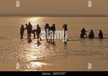 Pilger stehen im Wasser bei Sangam, dem Zusammenfluss der heiligen Flüsse Ganges, Yamuna und Saraswati Stockfoto