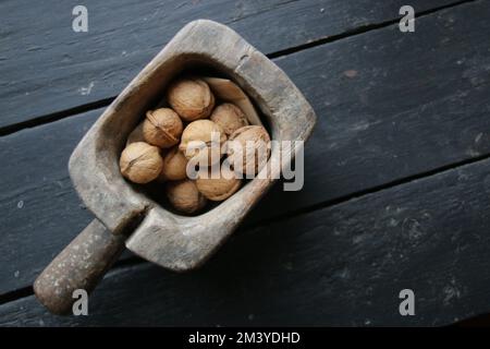Walnüsse-Nahaufnahme in einer alten Holzkiste. Stockfoto