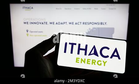 Person, die ein Handy mit dem Logo der britischen Erdölgesellschaft Ithaca Energy auf dem Bildschirm vor der Unternehmenswebseite hält. Konzentrieren Sie sich auf das Display des Telefons. Stockfoto