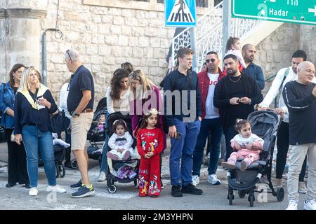 Haifa, Israel - 17. Dezember 2022 : Schüler der St. Elias Bischofsschule nimmt an der Weihnachtsparade in der deutschen Kolonie Teil. Die Zuschauer beobachten sie Stockfoto