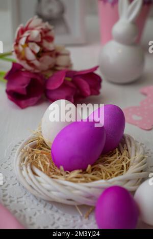 Eine Nahaufnahme rosa gefärbter Eier auf einem künstlichen Nest Stockfoto