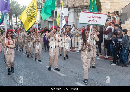 Haifa, Israel - 17. Dezember 2022 : Schüler der St. Elias Bischofsschule nimmt an der Weihnachtsparade in der deutschen Kolonie Teil. Die Zuschauer beobachten sie Stockfoto