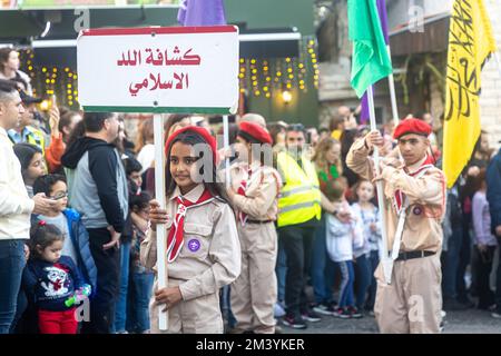 Haifa, Israel - 17. Dezember 2022 : Schüler der St. Elias Bischofsschule nimmt an der Weihnachtsparade in der deutschen Kolonie Teil. Die Zuschauer beobachten sie Stockfoto