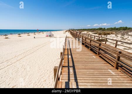 Breiter Sandstrand mit Holzbrücken entlang der Dünen in Monte Gordo, Algarve, Portugal Stockfoto