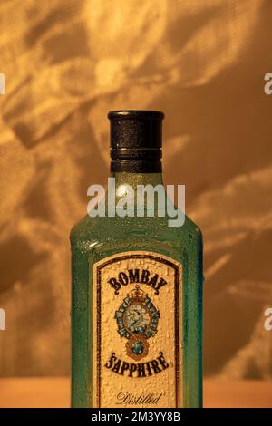 Eine vertikale Nahaufnahme einer Bombay Sapphire Gin-Flasche mit Wassertropfen Stockfoto