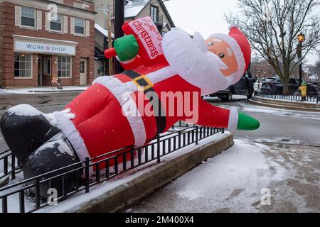 Chicago, USA. 16. Dezember 2022 Eine aufgeblasene Weihnachtsmann-Dekoration vor einem Laden in der Vorstadt von Chicago. Kredit: Stephen Chung / Alamy Stockfoto