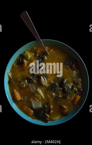 Winterspeisen. Heiße, würzige Currysuppe mit Meeresfrüchten, Fleisch und lokalem Bio-Gemüse, serviert in rustikaler Keramikschale. Stockfoto