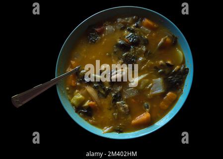 Winterspeisen. Heiße, würzige Currysuppe mit Meeresfrüchten, Fleisch und lokalem Bio-Gemüse, serviert in rustikaler Keramikschale. Stockfoto