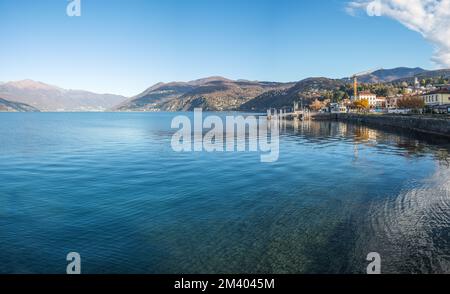 Extra Weitwinkelblick auf die Promenade am See in Luino mit den Bergen im Hintergrund Stockfoto