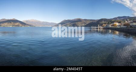 Extra Weitwinkelblick auf die Promenade am See in Luino mit den Bergen im Hintergrund Stockfoto