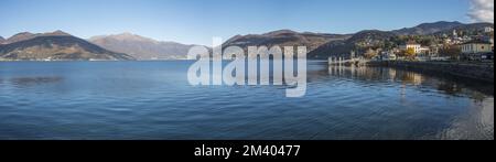 Extra Weitwinkelblick auf die Promenade am See in Luino mit den Bergen im Hintergrund Stockfoto