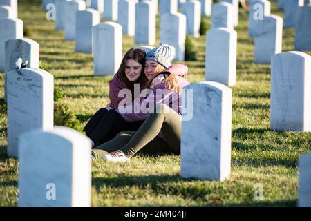 Arlington, Vereinigte Staaten Von Amerika. 17.. Dezember 2022. Arlington, Vereinigte Staaten von Amerika. 17. Dezember 2022. Freiwillige bestaunen das Grab eines gefallenen Soldaten während der 31. Kränze am America Day auf dem Arlington National Cemetery am 17. Dezember 2022 in Arlington, Virginia. Mehr als 30.000 Freiwillige platzieren 257.000 Kränze an jedem Grab des Nationalfriedhofs von Arlington und an anderen Orten im ganzen Land. Kredit: Elizabeth Fraser/US Army Foto/Alamy Live News Stockfoto