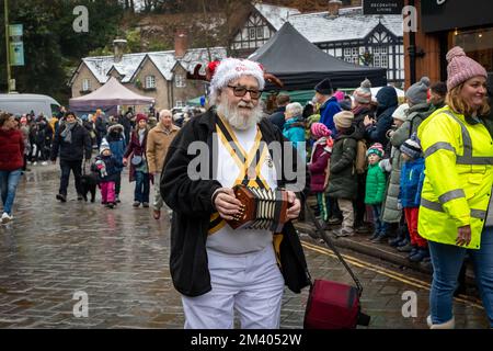 Ein Mann, der bei der Grand Parade auf dem Lymm Dickensian Christmas Festival eine Squeeze Box spielt Stockfoto