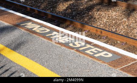 Denken Sie an die Stufenwarnung auf einem Bahnsteig an einem Bahnhof. Stockfoto