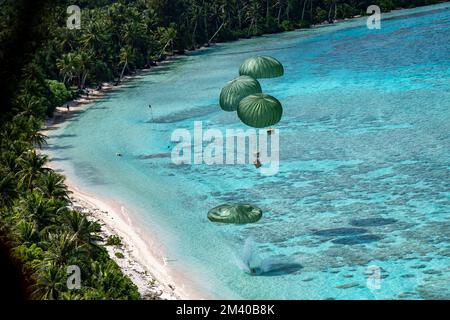 Fananu-Atoll, Föderierte Staaten von Mikronesien. 09. Dezember 2022. Humanitäres Bündel Fallschirm in eine Lagune von einem US Air Force C-130J Super Hercules Flugzeug, das der 36. Expeditionary Airlift Squadron zugeteilt wurde, während Operation Christmas Drop 2022, 9. Dezember 2022 in Fananu Atoll, Chuuk, Mikronesien. Operation Christmas Drop ist die älteste humanitäre und Katastrophenhilfemission, die 71.000 Pfund Nahrungsmittel, Geschenke und Vorräte zur Unterstützung abgelegener Inselgemeinden im Südpazifik liefert. Kredit: Yasuo Osakabe/US Airforce Photo/Alamy Live News Stockfoto