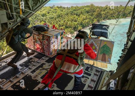 Fananu-Atoll, Föderierte Staaten von Mikronesien. 09. Dezember 2022. Die US Air Force-Lastmeister schieben humanitäre Bündel aus der offenen Rampe eines C-130J Super Hercules-Flugzeugs, das dem 36. Expeditionary Airlift Squadron zugeteilt wurde, während Operation Christmas Drop 2022, 9. Dezember 2022 in Fananu Atoll, Chuuk, Mikronesien. Operation Christmas Drop ist die älteste humanitäre und Katastrophenhilfemission, die 71.000 Pfund Nahrungsmittel, Geschenke und Vorräte zur Unterstützung abgelegener Inselgemeinden im Südpazifik liefert. Kredit: Yasuo Osakabe/US Airforce Photo/Alamy Live News Stockfoto