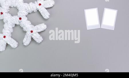 Retro-Bilderrahmen isoliert auf grauem Hintergrund. Vorlage für echte Fotos. Zwei Rahmen. Modell. Weihnachtliche weiße Schneeflocke. Winterdekoration Stockfoto