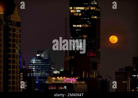 Bilder: „Cold Moon“ - Mondaufgang über dem Mahanakhon-Gebäude, Bangkok in Thailand. Der Vollmond im Dezember, auch bekannt als „Kaltmond“, wird strahlen Stockfoto