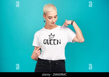 Es ist eine Welt der Königinnen und alle lebten darin. Studioaufnahme einer selbstbewussten jungen Frau, die ein T-Shirt mit Queen-Shirt auf türkisfarbenem Hintergrund trägt Stockfoto