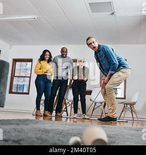 Gehen Sie Ihre Chancen im Leben und im Geschäft ein. Gesamtbild eines Geschäftsmanns, der in seinem Büro Golf spielt, während seine Kollegen ihm im die Daumen drücken Stockfoto