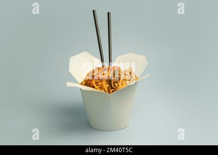 Koreanische Nudeln in weißer Schachtel auf blauem Hintergrund. Asiatisches Essen Stockfoto