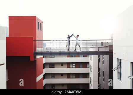 Mach weiter mit allen deinen Zielen. Ein sportlicher junger Mann und eine sportliche Frau, die sich gegenseitig beim Sport im Freien einen High Five geben. Stockfoto