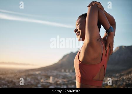 Berg-, Fitness- und Stretching-Frau mit Lächeln für Lauftore, Erfolg oder Trainingsfreiheit auf dem Blue-Sky-Modell. Das Muskelwohl des Sportschwarzes Stockfoto