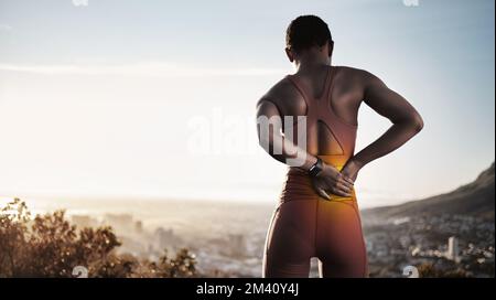 Schwarze Läuferin, Rückenschmerzen und Bewegung am Morgen, Sommer und in der Stadt mit Skyline, Smartwatch und Ruhe. Urbanes Training, Muskelverletzung oder Selbstpflege Stockfoto