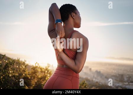 Fitness, schwarze Frau und Stretching Arm auf dem Berg in Kapstadt für Muskelgesundheit, gesunde Ziele und Energie. Sportler, warm-up und Mobilität für Stockfoto