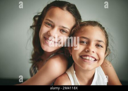 Es gibt keine Verbindung wie die von Schwestern. Zwei junge Mädchen, die zu Hause Zeit miteinander verbringen. Stockfoto