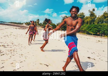 Lokale Gruppe von Menschen mit typisch kenianischen Kleidern, die am Strand tanzen Stockfoto